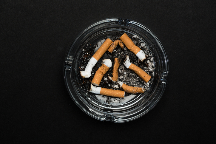Ashtray with cigarettes on black background